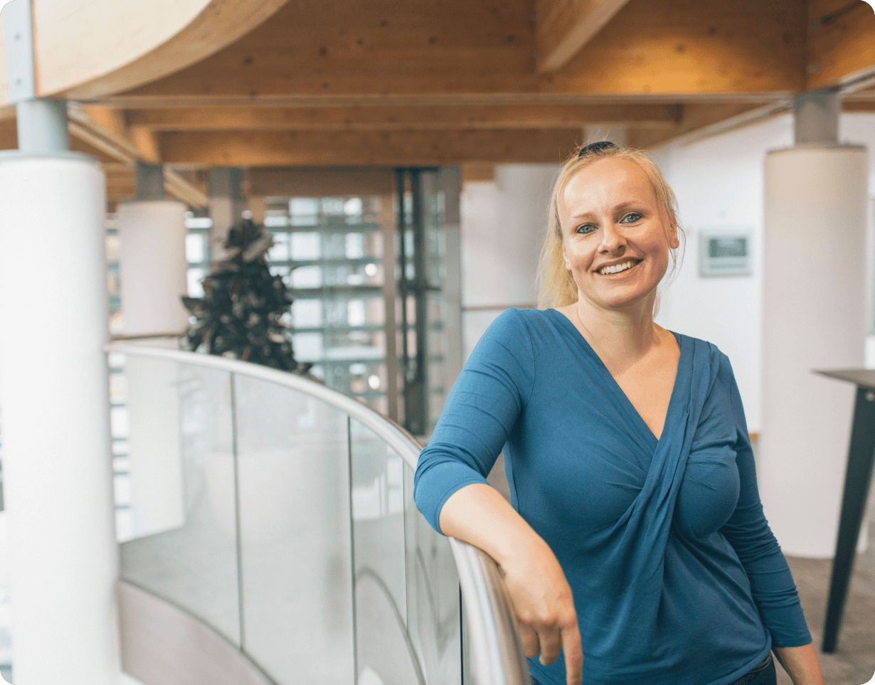 Kathleen Meyer leaning against a balcony in an Altos Labs office